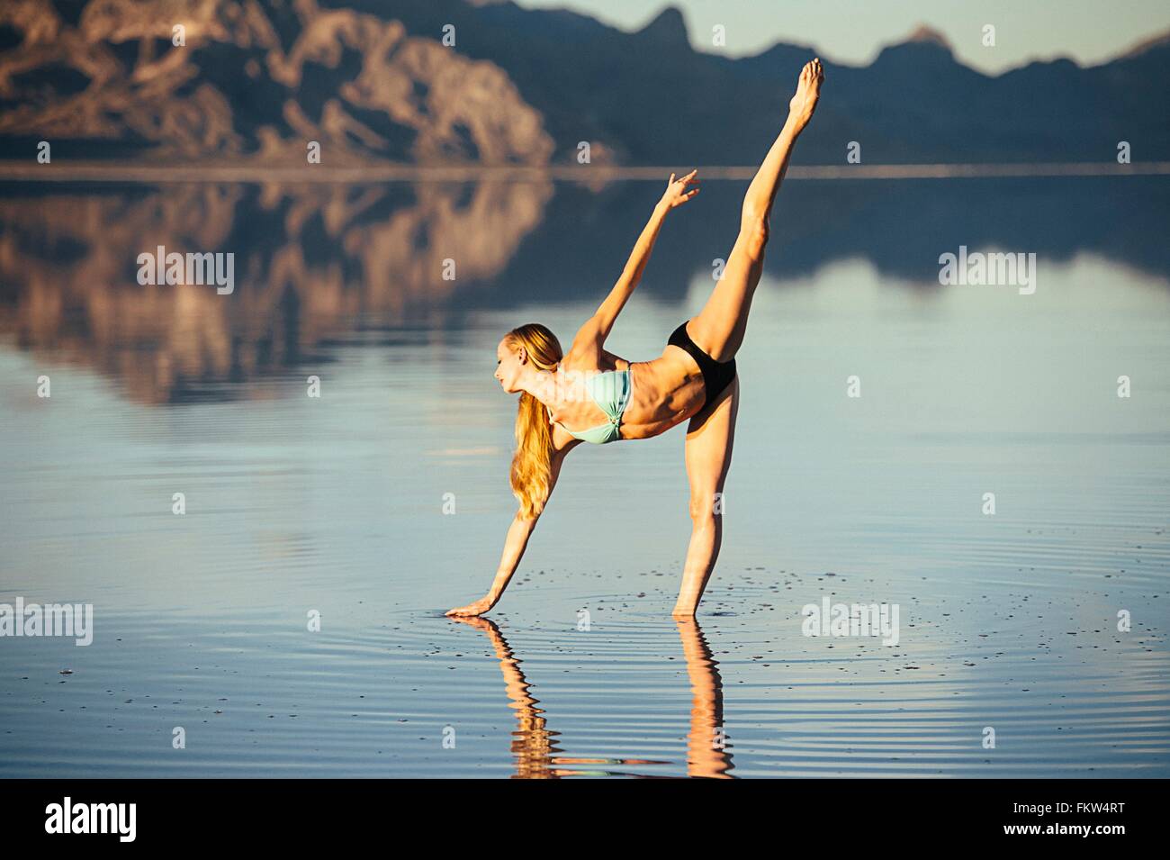 Femmina danzatore di balletto in bilico nel balletto posizione nel lago di Bonneville Saline, Utah, Stati Uniti d'America Foto Stock