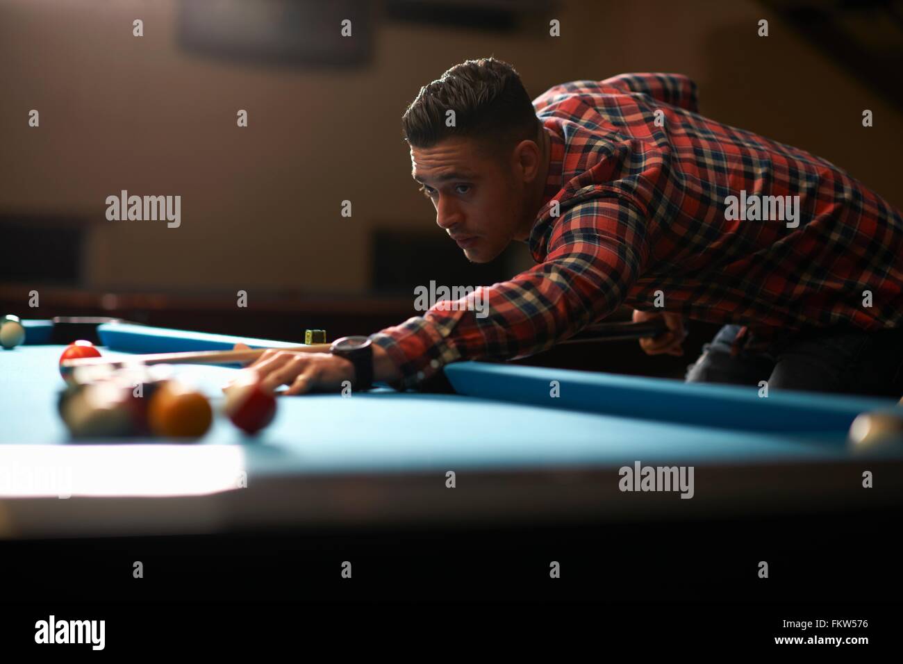 L'uomo giocando a biliardo nel club Foto Stock