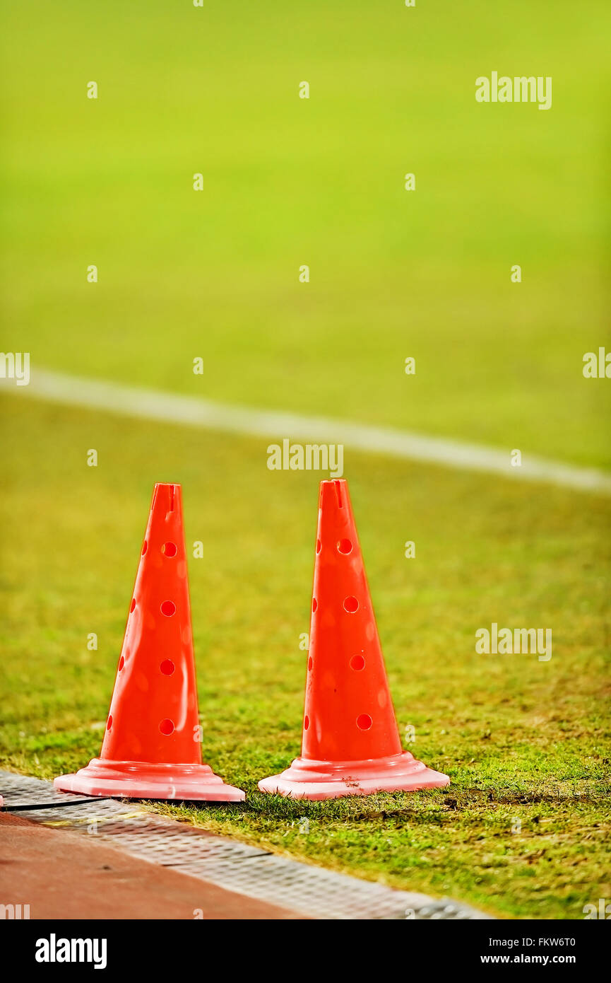 Arancione marcatore calcio coni per la formazione sono visto sul marginale di un campo di calcio Foto Stock