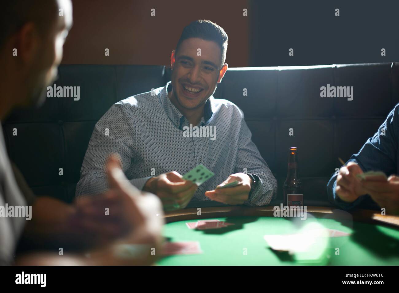 Uomo di fronte a giocare a carte per il gioco a pub nella tabella della scheda Foto Stock