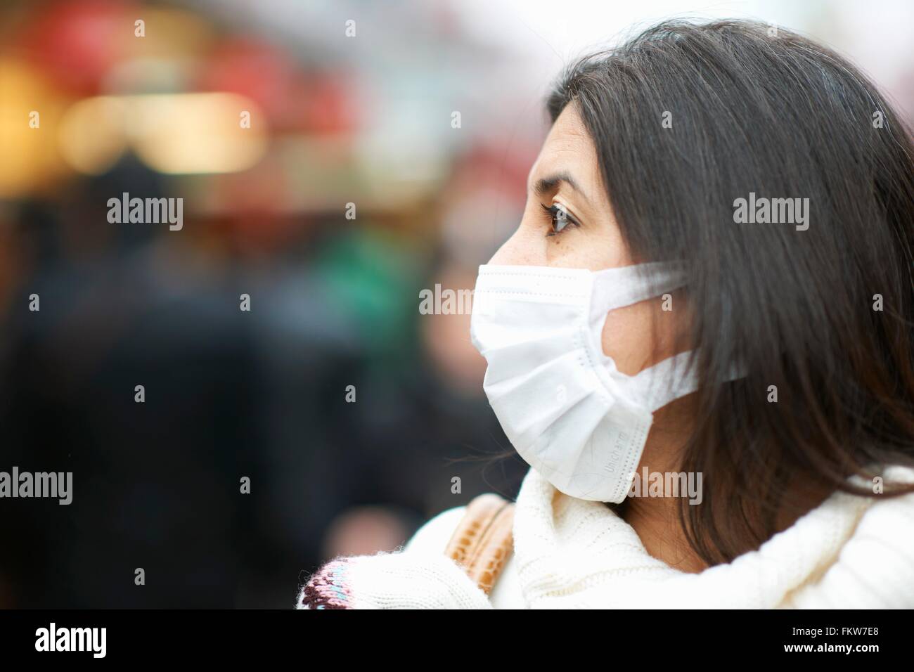 Close up di donna matura che indossa la maschera di inquinamento, Tokyo, Giappone Foto Stock