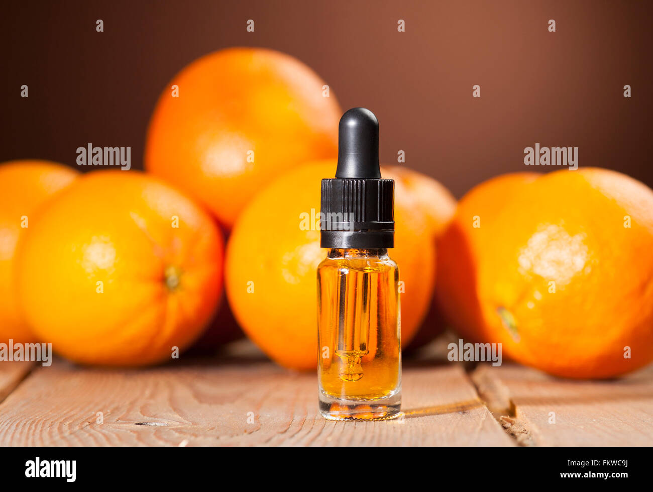 Bottiglia di olio essenziale di arance su sfondo di legno - medicina alternativa Foto Stock
