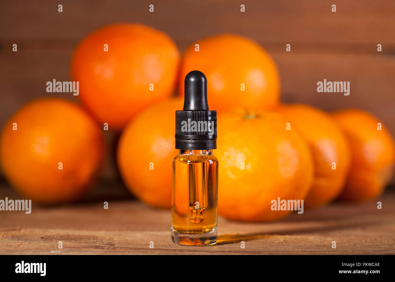 Bottiglia di olio essenziale di arance su sfondo di legno - medicina alternativa Foto Stock