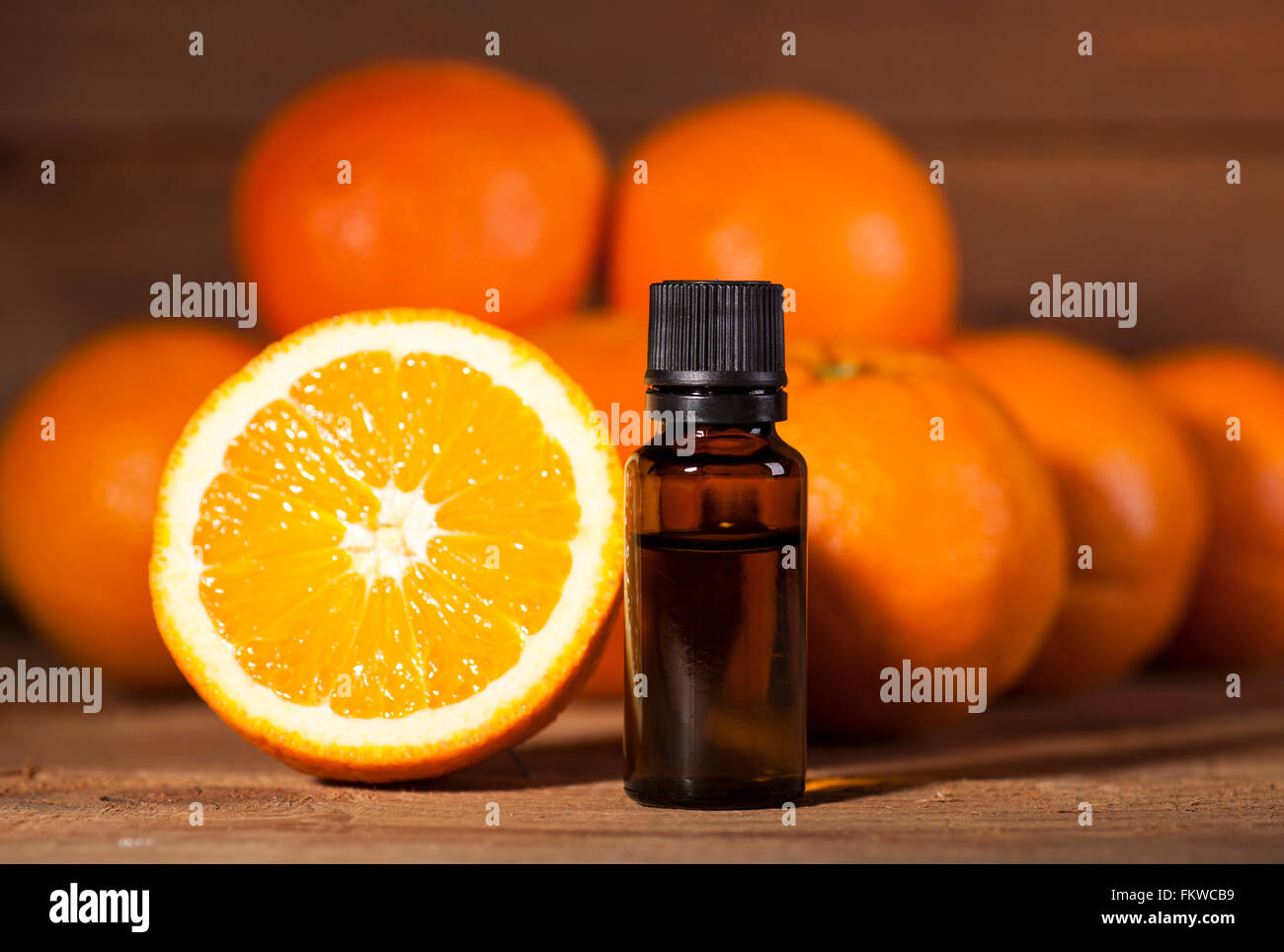Bottiglia di olio essenziale di arance su sfondo di legno - medicina alternativa Foto Stock