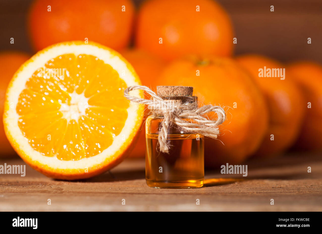 Bottiglia di olio essenziale di arance su sfondo di legno - medicina alternativa Foto Stock