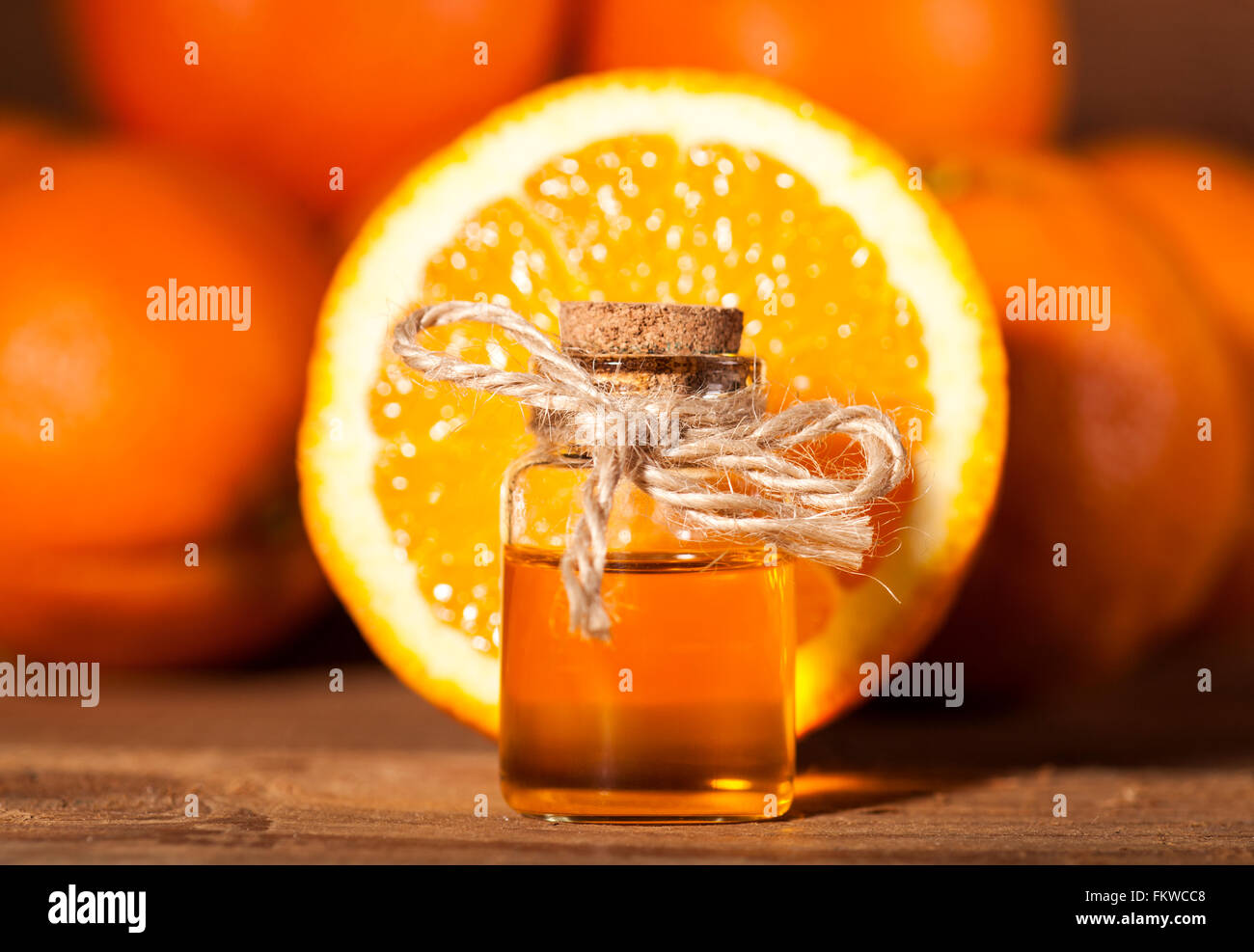 Bottiglia di olio essenziale di arance su sfondo di legno - medicina alternativa Foto Stock
