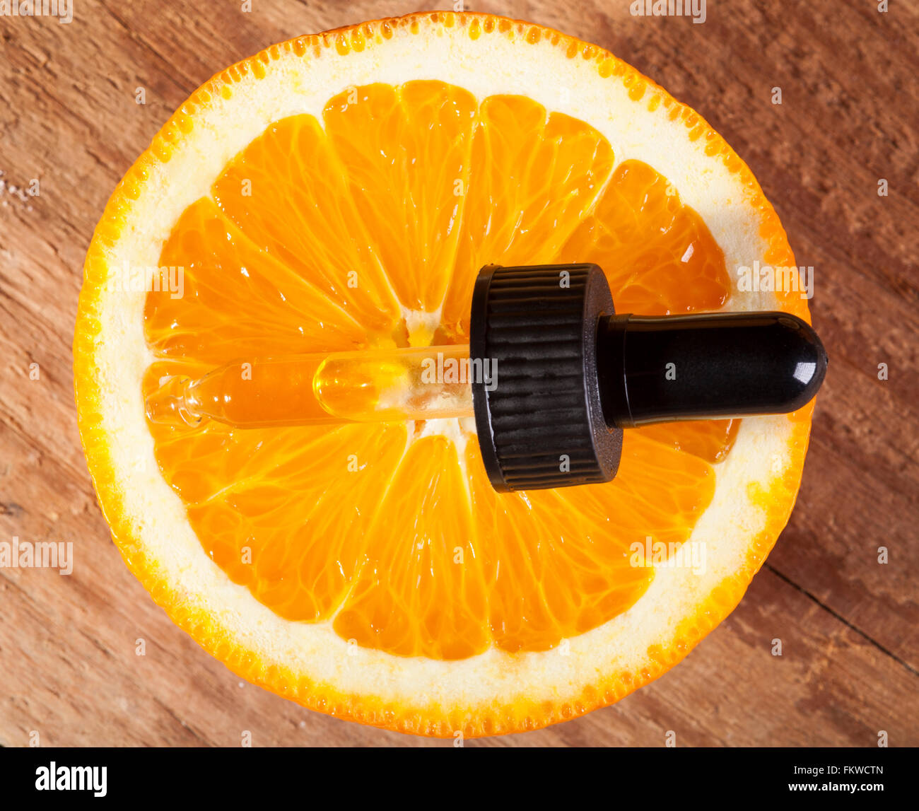 Bottiglia di olio essenziale di arance su sfondo di legno - medicina alternativa Foto Stock