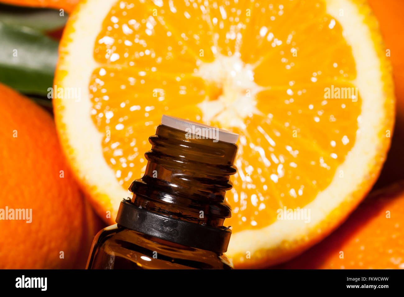 Bottiglia di olio essenziale di arance su sfondo di legno - medicina alternativa Foto Stock