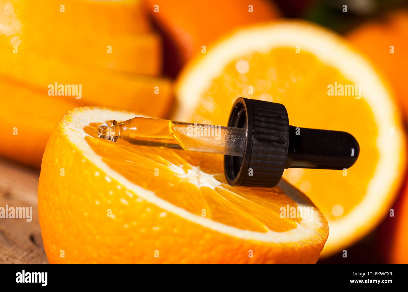 Bottiglia di olio essenziale di arance su sfondo di legno - medicina alternativa Foto Stock