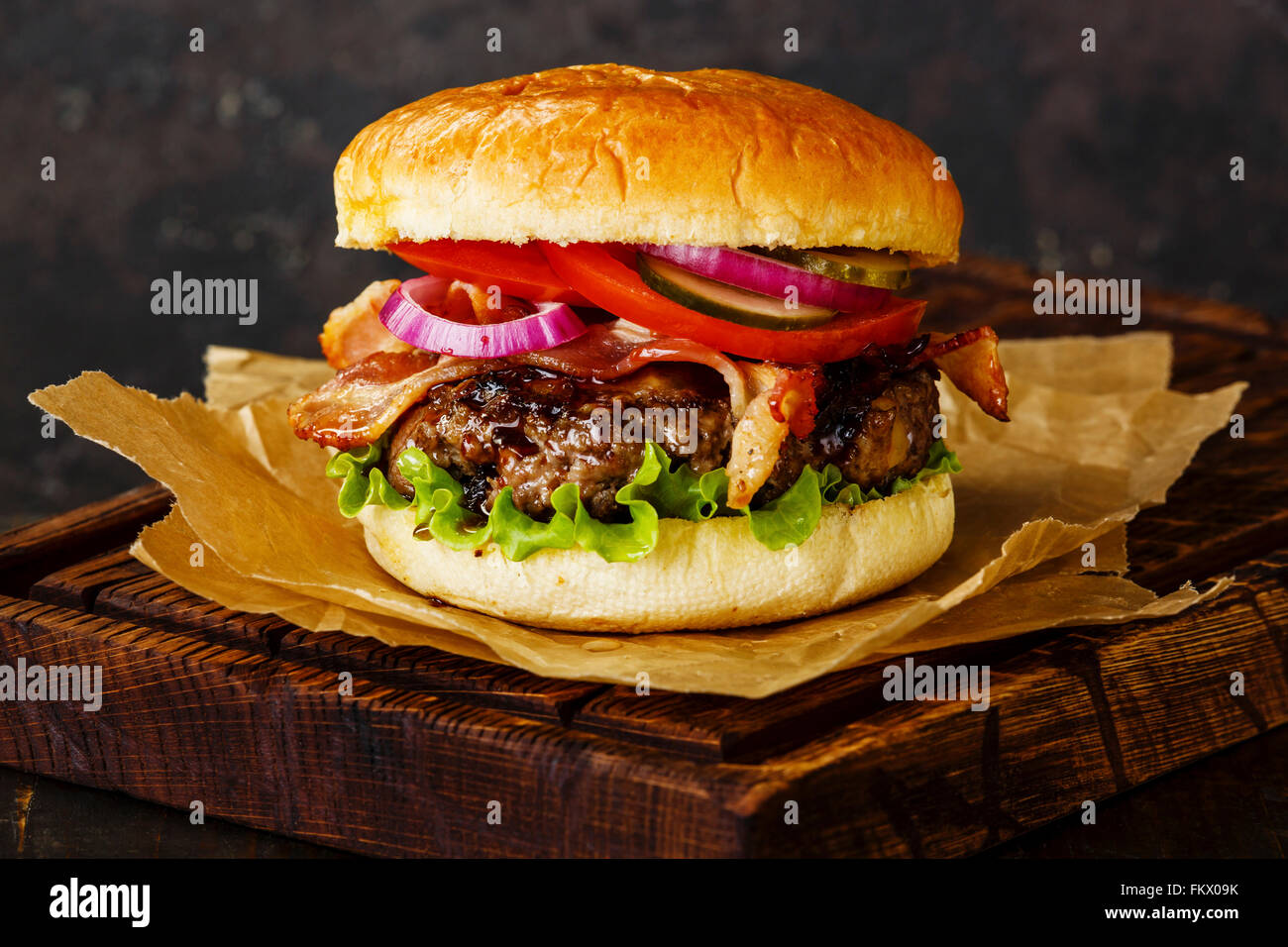 Burger con carne e pancetta affumicata su sfondo scuro Foto Stock