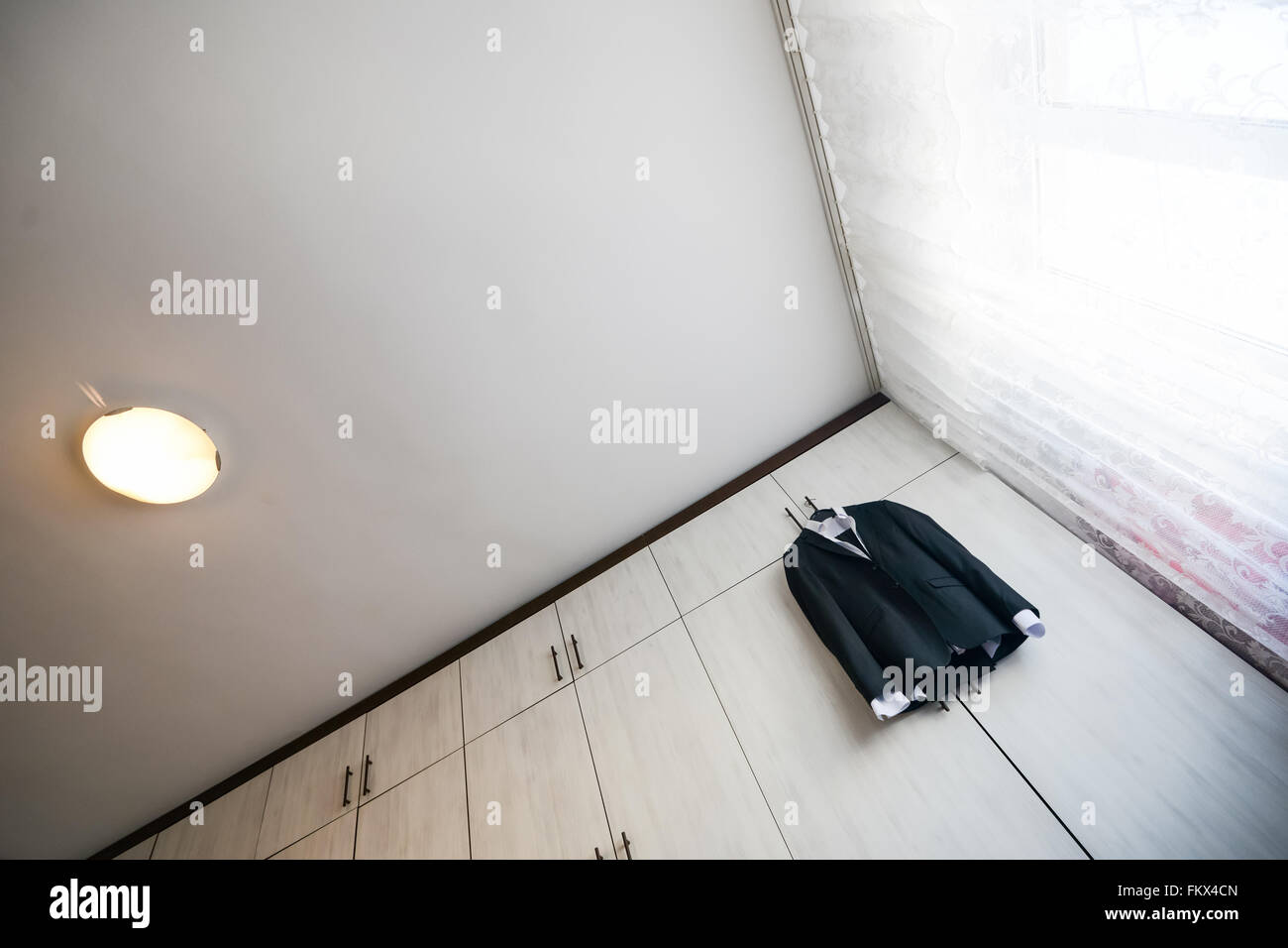 Abito nero con camicia pendente da un armadio in legno Foto Stock