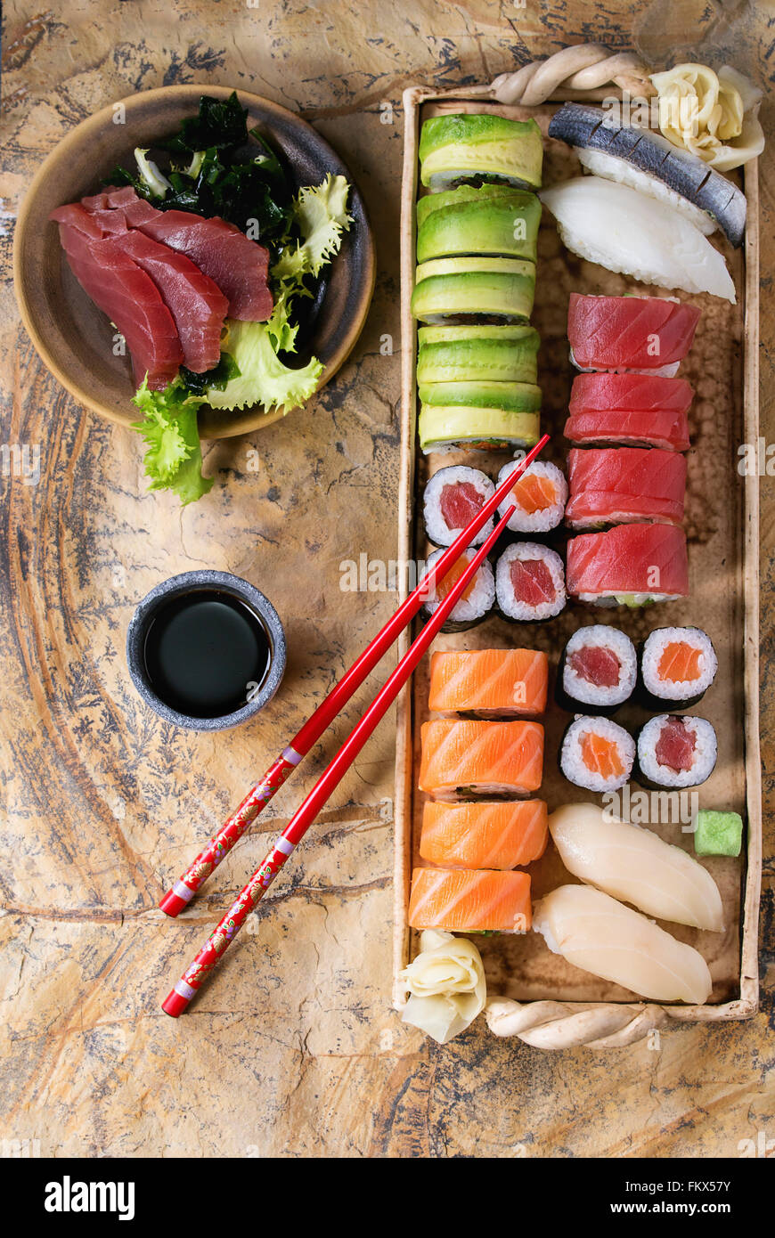 Set di sushi nigiri, sashimi e i rulli sulla piastra di argilla servita con  bacchette e salsa di soia sulla superficie di pietra. Lay piatto Foto stock  - Alamy