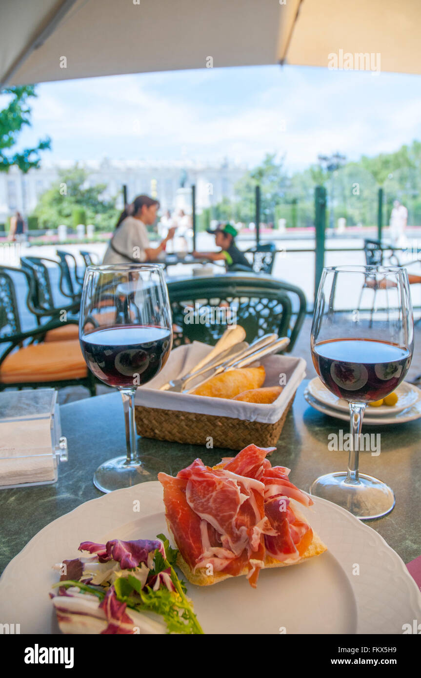 Lo spagnolo tapa: prosciutto iberico su toast e due bicchieri di vino rosso. Plaza Oriente, Madrid, Spagna. Foto Stock