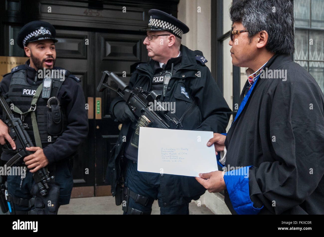 Londra, Regno Unito. Il 10 marzo 2016. Un portavoce ha le mani in una busta indirizzata all' ambasciatore cinese come tibetano londinesi si raccolgono al di fuori dell'Ambasciata della Cina in Portland Place chiamando per 'Giustizia in Tibet', prima di marciare attraverso il centro di Londra. Essi si erano riuniti per commemorare il 57 anniversario della Rivolta Nazionale Tibetana Giorno (quando migliaia di tibetani sono stati uccisi in una rivolta a Lhasa per proteggere il Dalai Lama da truppe Cinesi e di occupazione del proprio paese). Credito: Stephen Chung / Alamy Live News Foto Stock