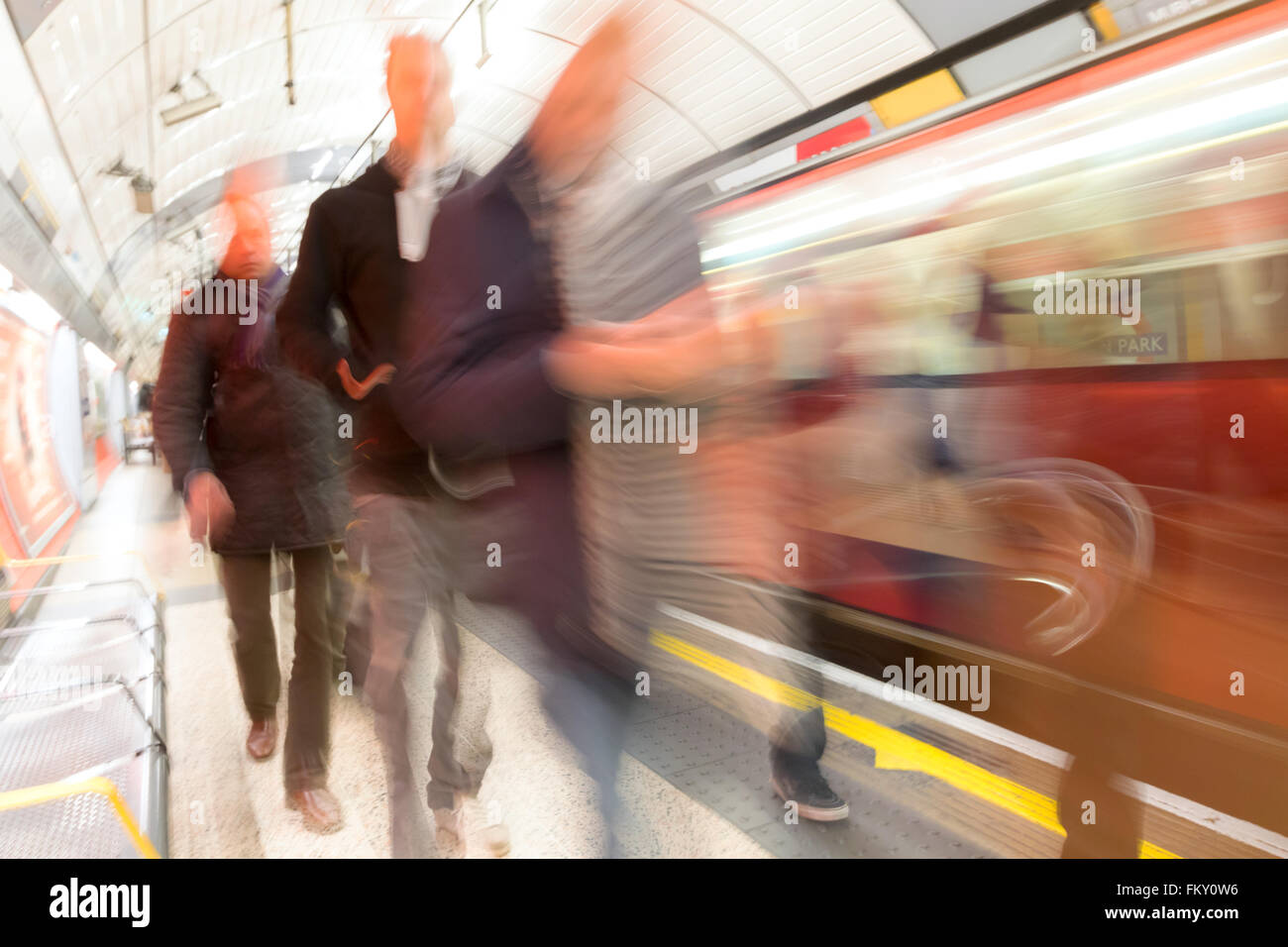 La metropolitana di Londra la stazione del treno passeggeri sulla piattaforma, motion blur, Green Park Tube Station, London REGNO UNITO Foto Stock