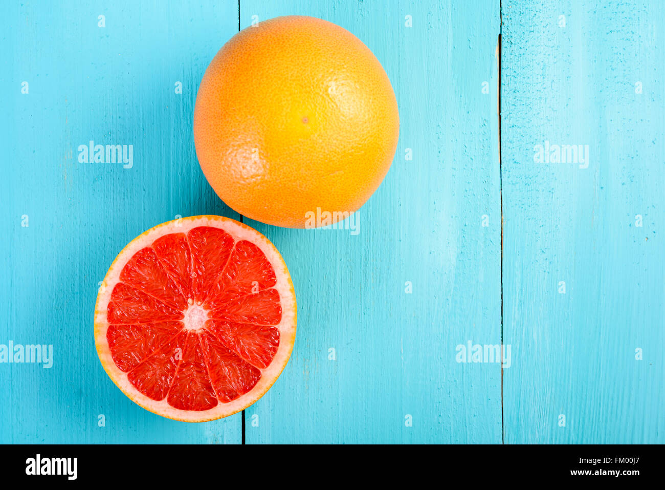 Rosso fresco fetta di pompelmo sulla tavola di legno Foto Stock