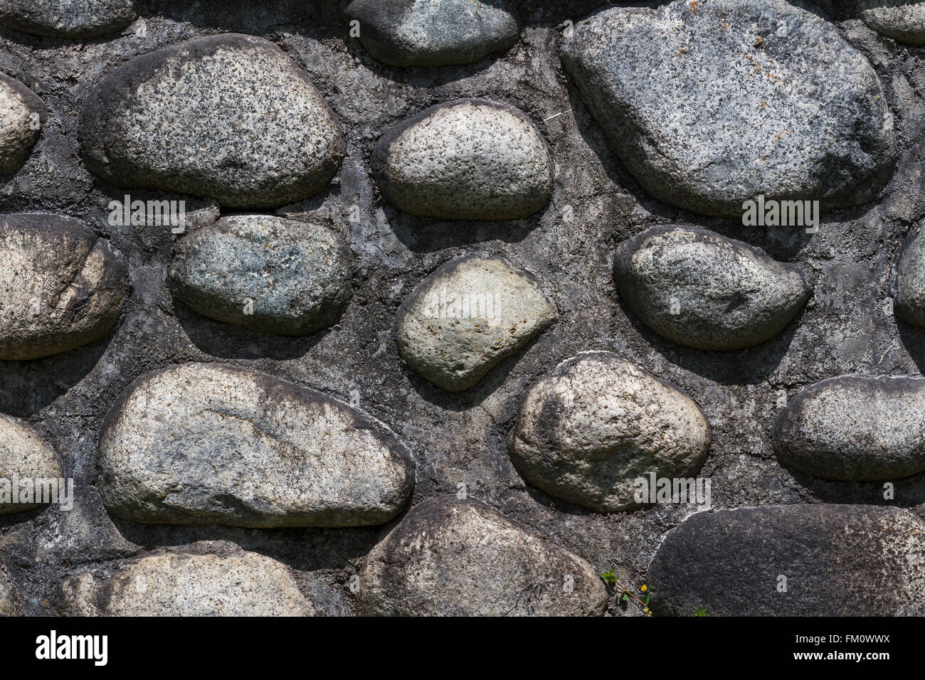 Sfondo costituito di un primo piano di una parete con ciottoli e sabbia Foto Stock