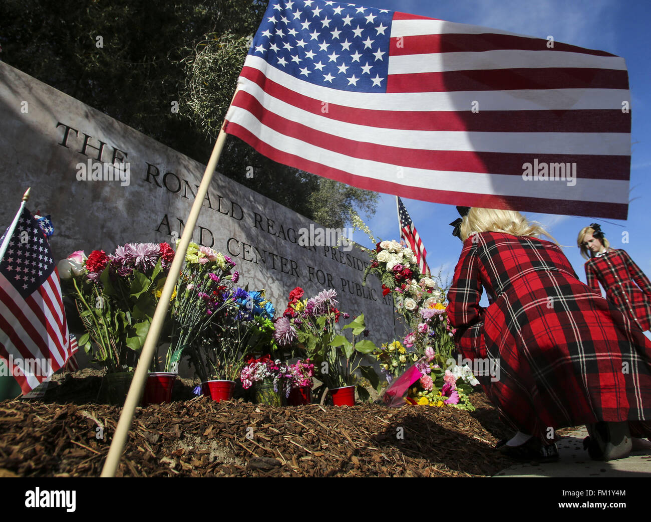 Los Angeles, California, USA. Decimo Mar, 2016. Persone fiori di laici a un memoriale di fortuna per il ritardo di Nancy Reagan al di fuori del Ronald Reagan Presidential Library in Simi Valley, in California, il 10 marzo 2016. Ci ex first lady Nancy Reagan era giacente in riposo a suo marito della biblioteca presidenziale su, con i membri del pubblico prestando la loro ultima rispetta davanti a un funerale privato. Credito: Ringo Chiu/ZUMA filo/Alamy Live News Foto Stock