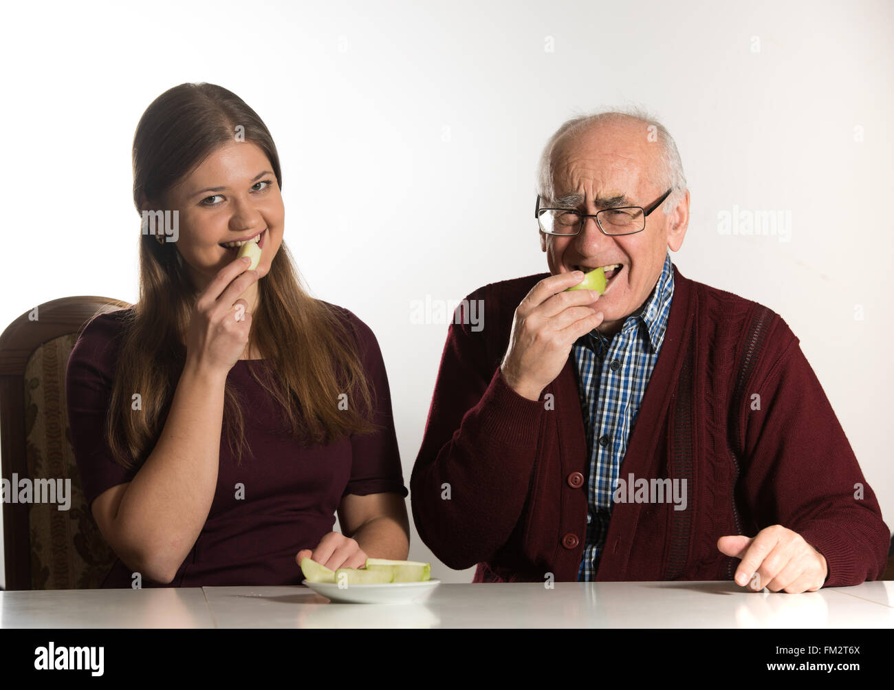 Giovane donna e uomo senior mangiare mela verde Foto Stock