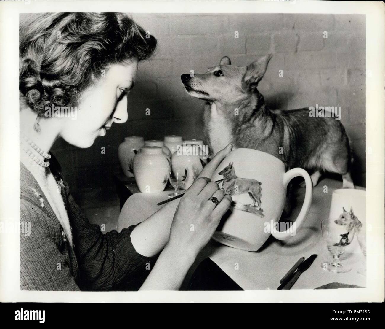 1958 - Buffer non è Duffer quando si tratta di porre la Corgi Queen Elizabeth preferito di razza di cane (ha due), orneranno dipinte a mano e tazze, piatti, bicchieri e vetreria per essere mostrato al prossimo anno British Industries Fair, Londra e Birmingham da maggio 3-14. La ceramica saranno esposte dal sig. Dulcie Vaughan, che con un team di 14 assistenti mano-vernici prodotti per l'esportazione in tutto il mondo. Mostra immagine:- ''Buffer, '' 5-year-old Corgi colpisce una posa professionale con facilità mentre egli è dipinta su un bicchiere. Ogni disegno è fatto individualmente da un disegno o modello dal vivo - i trasferimenti sono Foto Stock