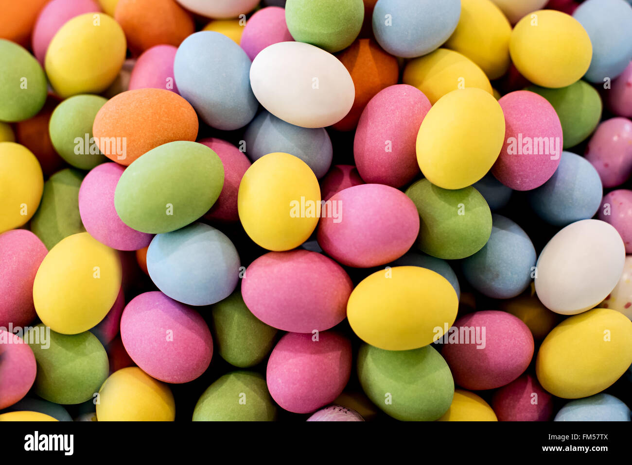 Sfondo colorato e rivestite di zucchero le uova di Pasqua di cioccolata Foto Stock