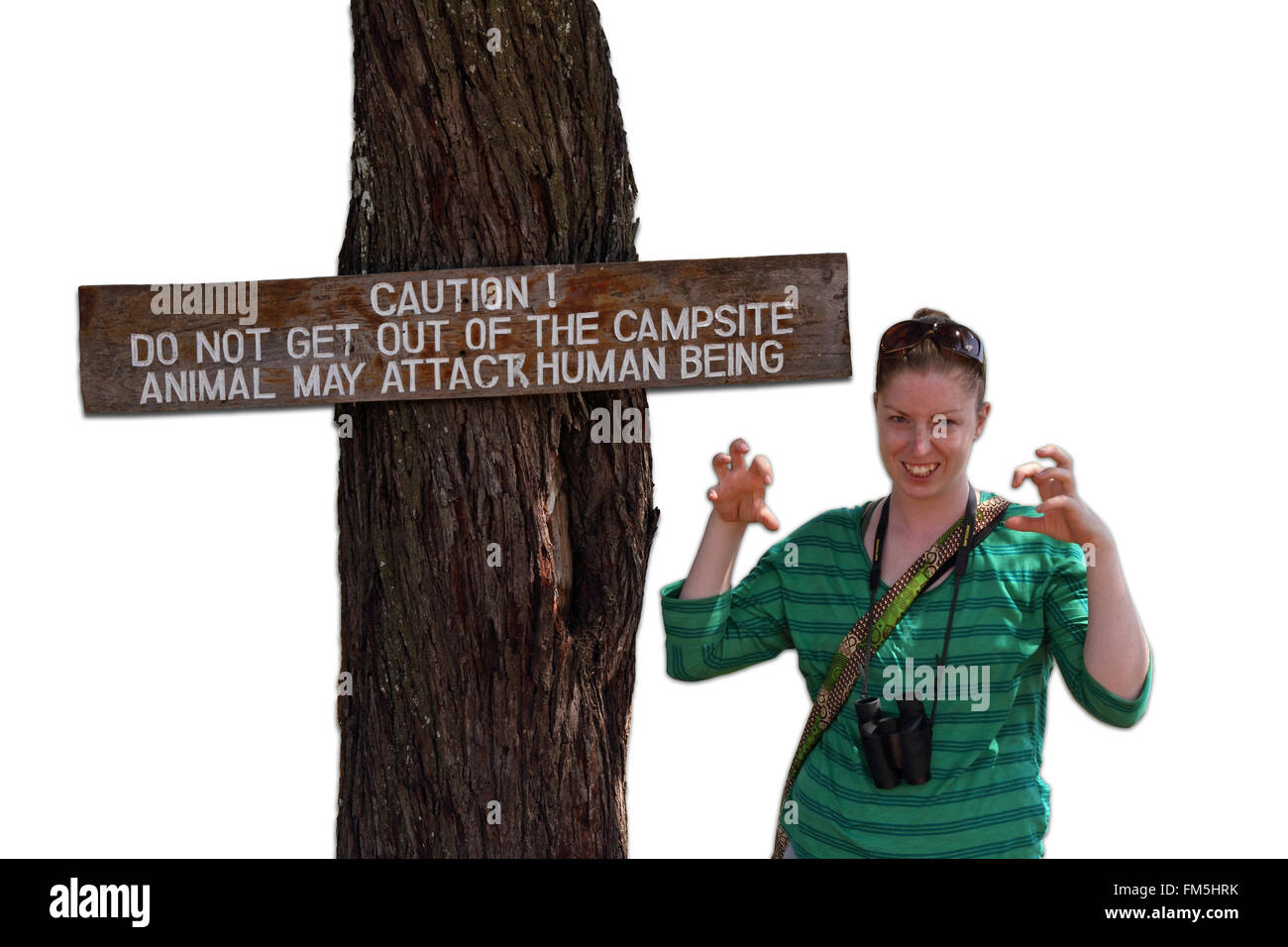 Una donna finge di essere un animale spaventoso accanto a un cartello che ammonisce gli esseri umani che gli animali possono attaccare se si lascia il campeggio. Foto Stock
