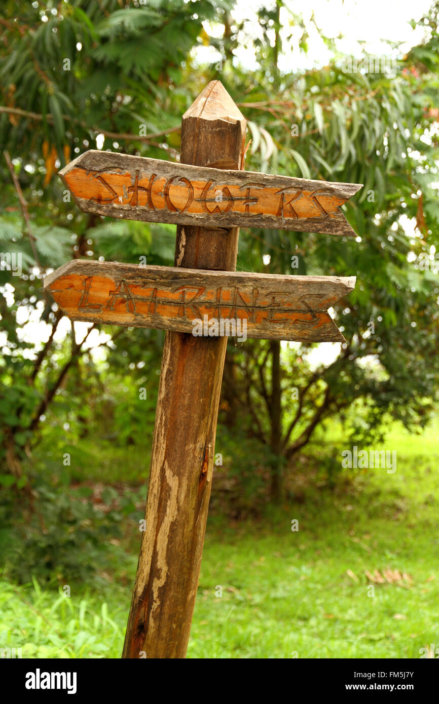 Un vecchio e la pelatura cartello in legno che indica la via verso le latrine e docce Foto Stock