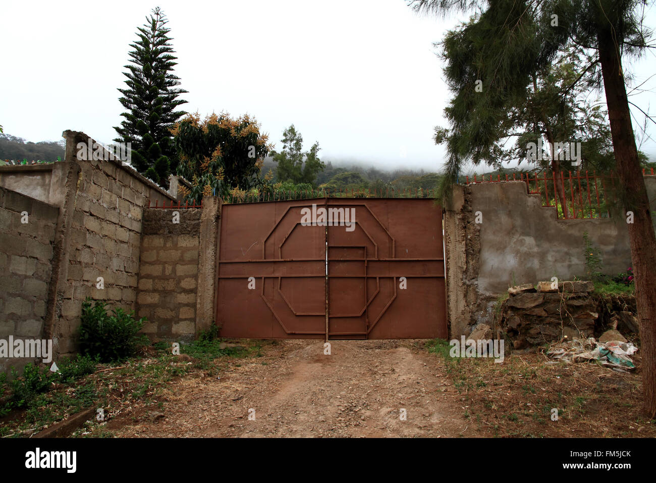 Porta ad un composto alla fine di un viale di ingresso Foto Stock