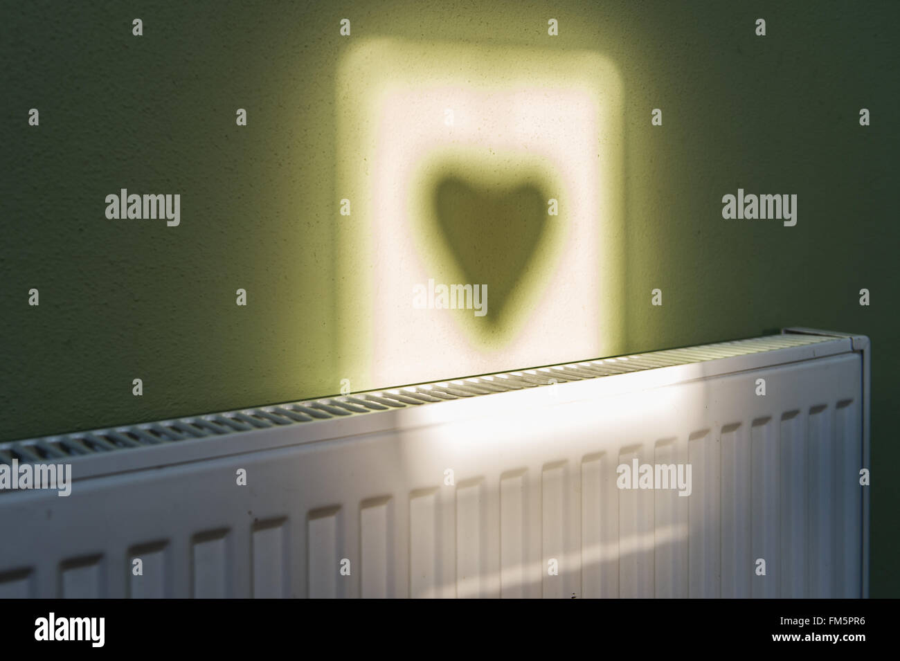 Silhouette cardiaca su un muro realizzato da Sun con copia spazio. Foto Stock