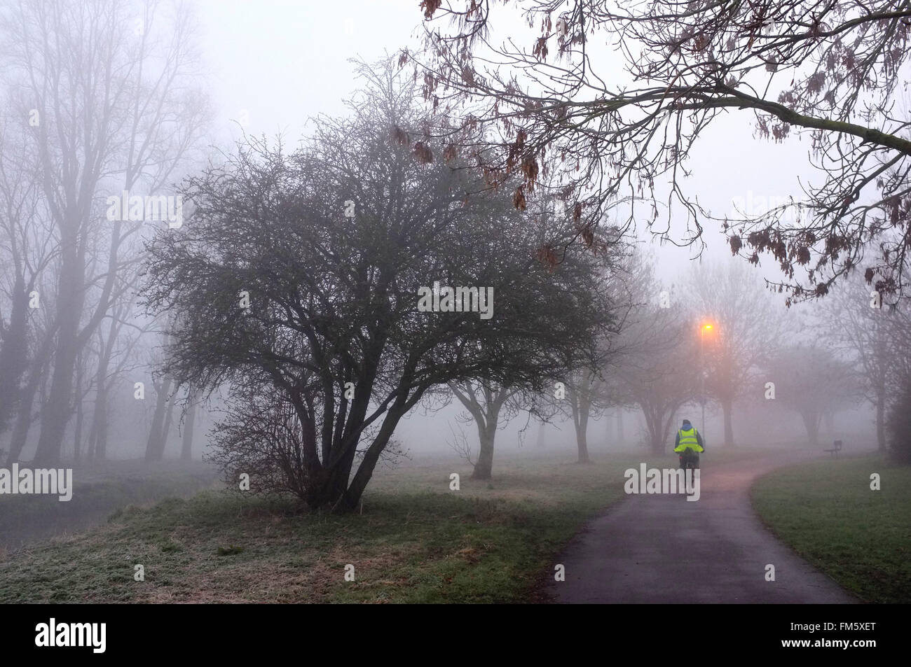 Escursioni in bicicletta sul sentiero nel parco su una mattinata nebbiosa a Luton, Bedfordshire Foto Stock