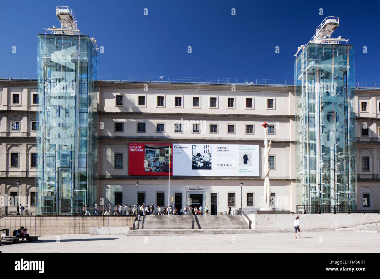 Una vista esterna di un edificio e l'entrata principale facciata per il Museo Nacional Centro de Arte Reina Sofia, Museo di Madrid con persone circa di fresatura esterna tra le due torri di vetrate con gli ascensori e le scale. Foto Stock