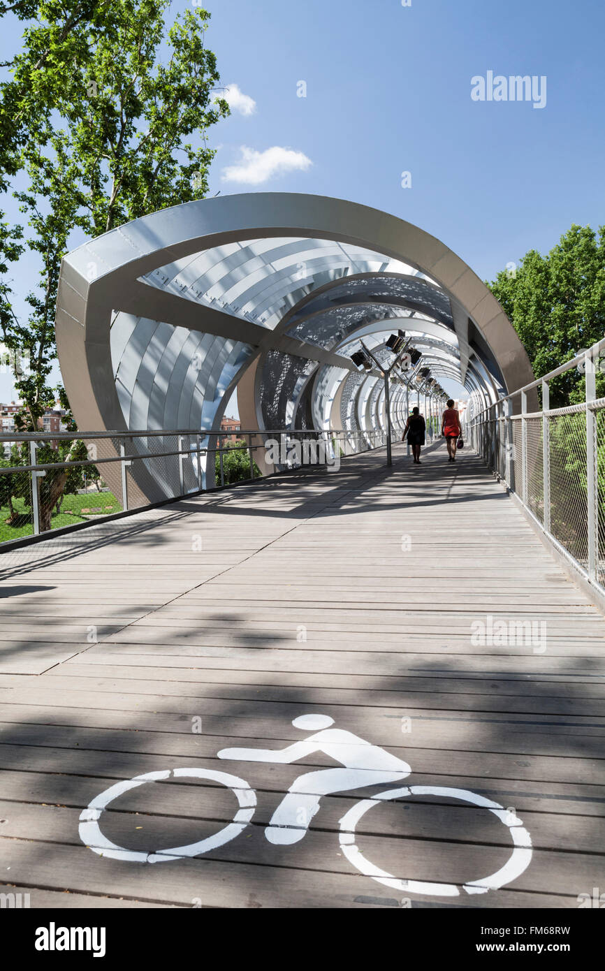 Una vista di un moderno ponte di nuovo a Madrid chiamato Pasarela del Arganzuela ponte pedonale, con due donne a piedi lungo di esso. Foto Stock