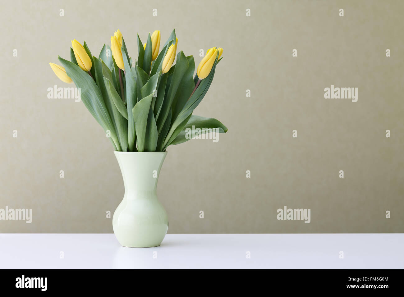 Tulipani gialli in un vaso verde Foto Stock