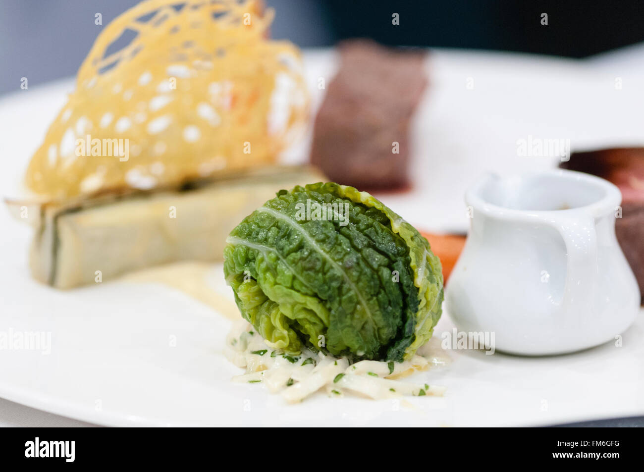 Un germoglio di Bruxelles perfettamente cucinati e presentati su un piatto in un ristorante. Foto Stock