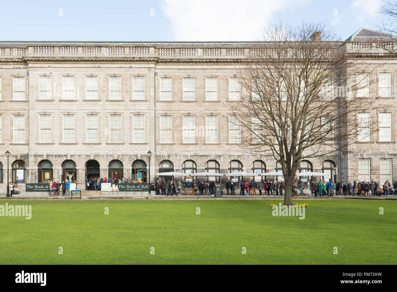 I turisti la gente in coda al di fuori della vecchia libreria del Trinity College di Dublino per visitare il Libro di Kells Foto Stock
