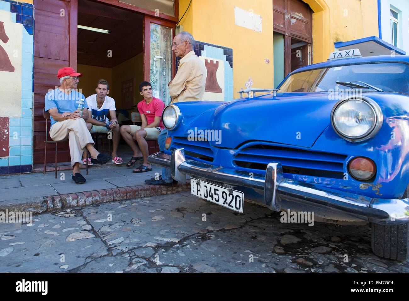 Cuba, Sancti Spiritus Provincia, Trinidad de Cuba elencati come patrimonio mondiale dall'UNESCO, la gente seduta dal club di scacchi e la vettura americana Foto Stock