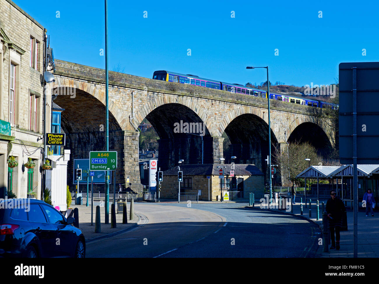 Treno sul viadotto ferroviario e il traffico nella strada, Todmorden, West Yorkshire, Inghilterra, Regno Unito Foto Stock