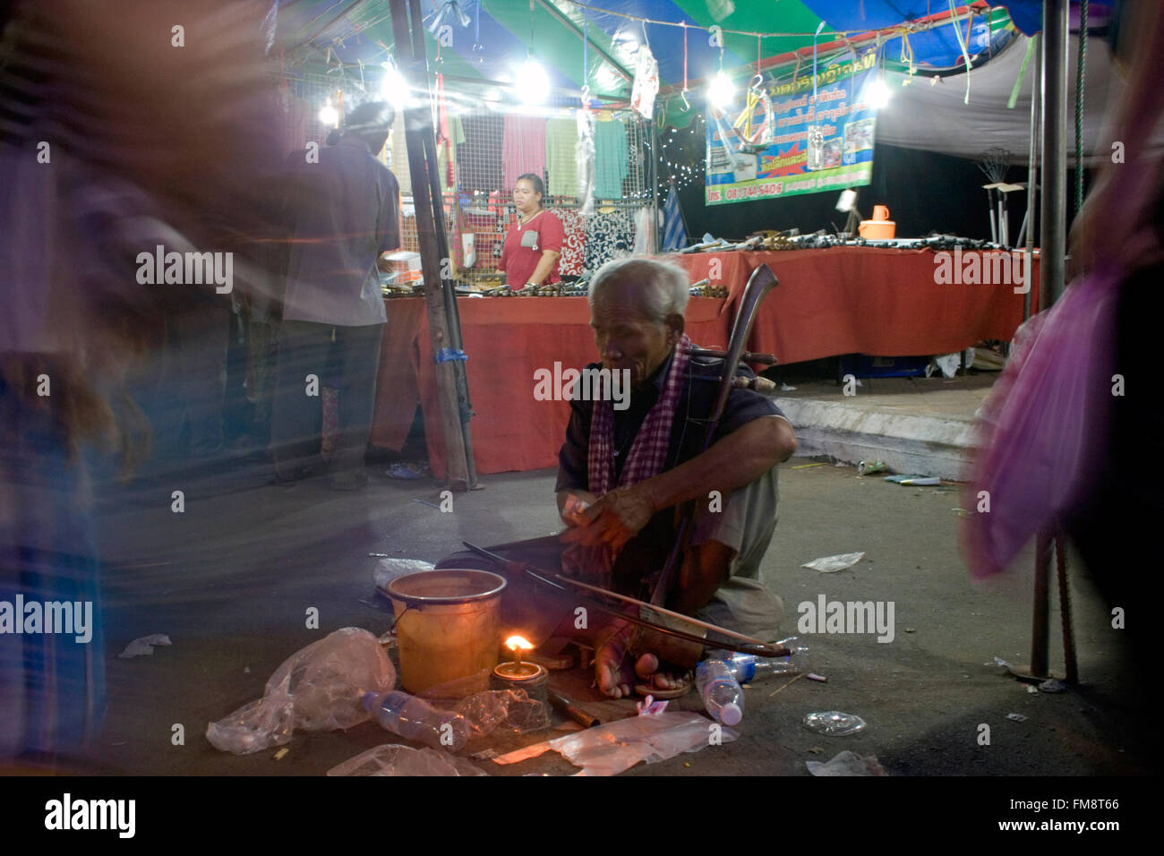 Un uomo senza visione (cieco) è la riproduzione di un tradizionale strumento musicale a una fiera di strada in Kampong Cham, Cambogia. Foto Stock
