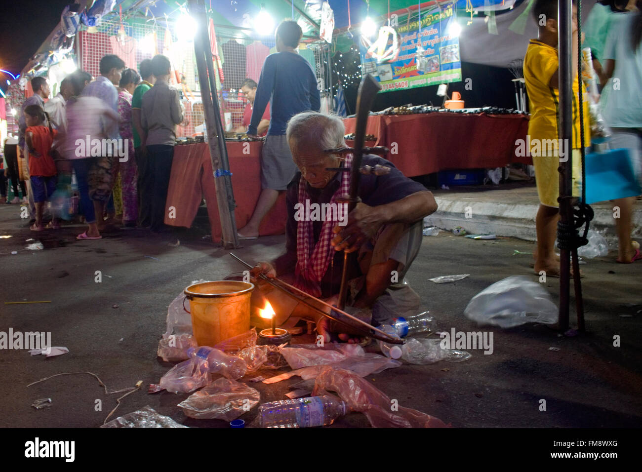 Un uomo senza visione (cieco) è la riproduzione di un tradizionale strumento musicale a una fiera di strada in Kampong Cham, Cambogia. Foto Stock