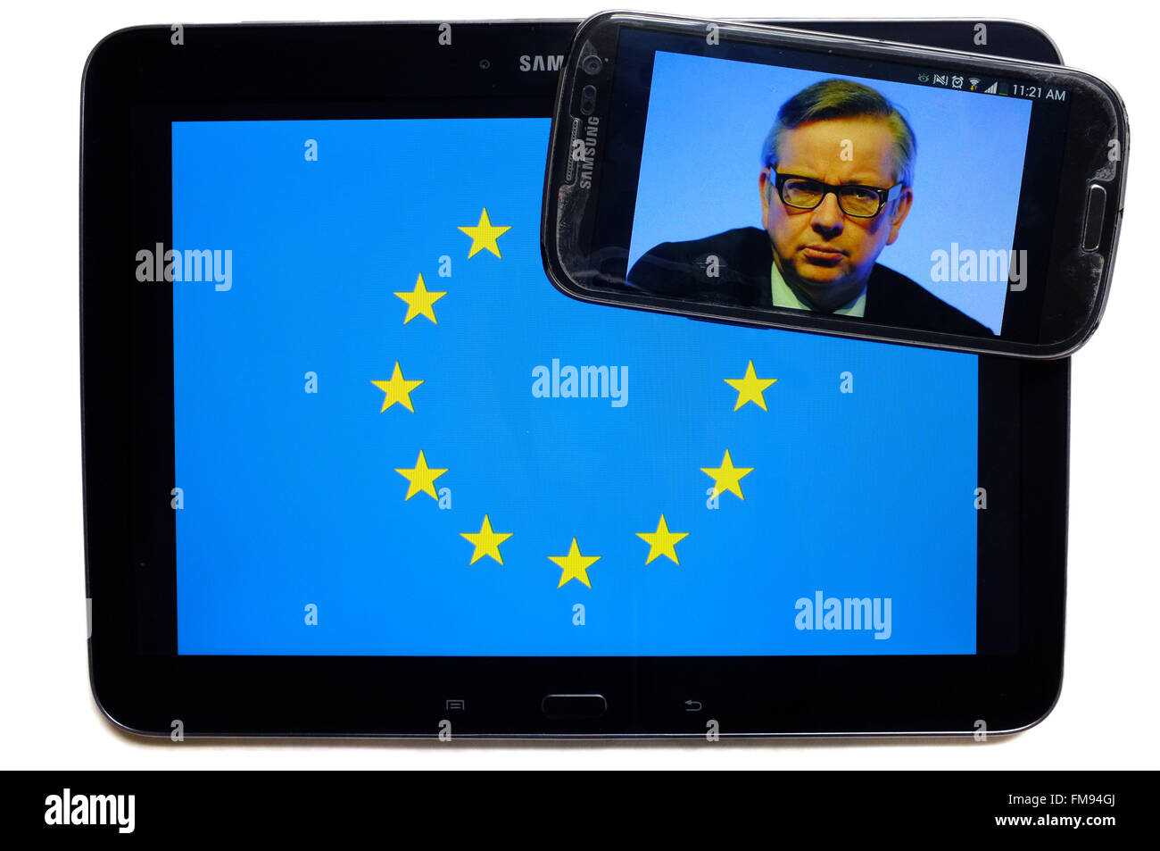 Uno smartphone con Michael Gove su di esso sulla parte superiore di un tablet con la bandiera dell'UE su di esso fotografati contro uno sfondo bianco. Foto Stock