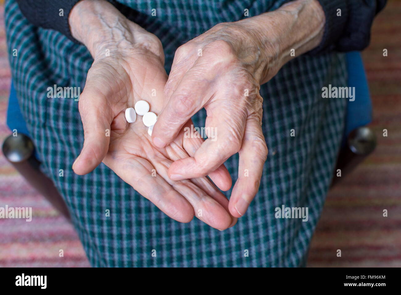 Mani di molto vecchia donna prendendo pillole Foto Stock