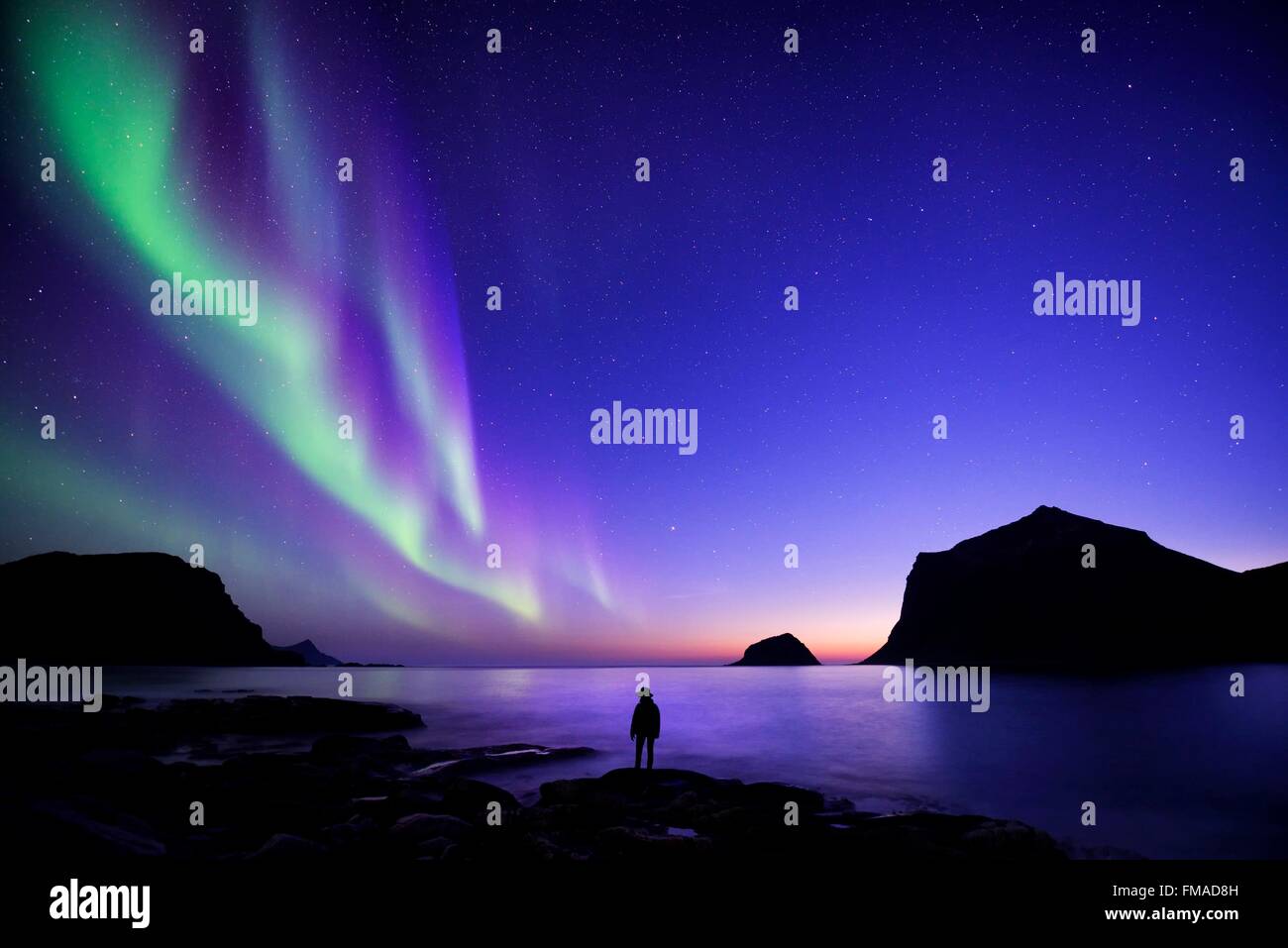 Norvegia, Nordland, isole Lofoten, isola Vestvagoy, Vik beach, silhouette di donna e di luci del nord (aurora boreale) Foto Stock