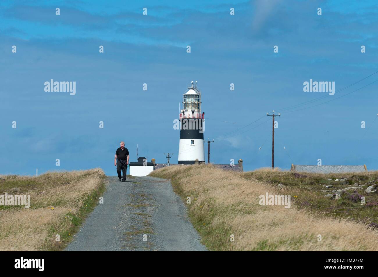 Irlanda, County Donegal, Tory Island Lighthouse, un uomo che cammina sulla strada Foto Stock