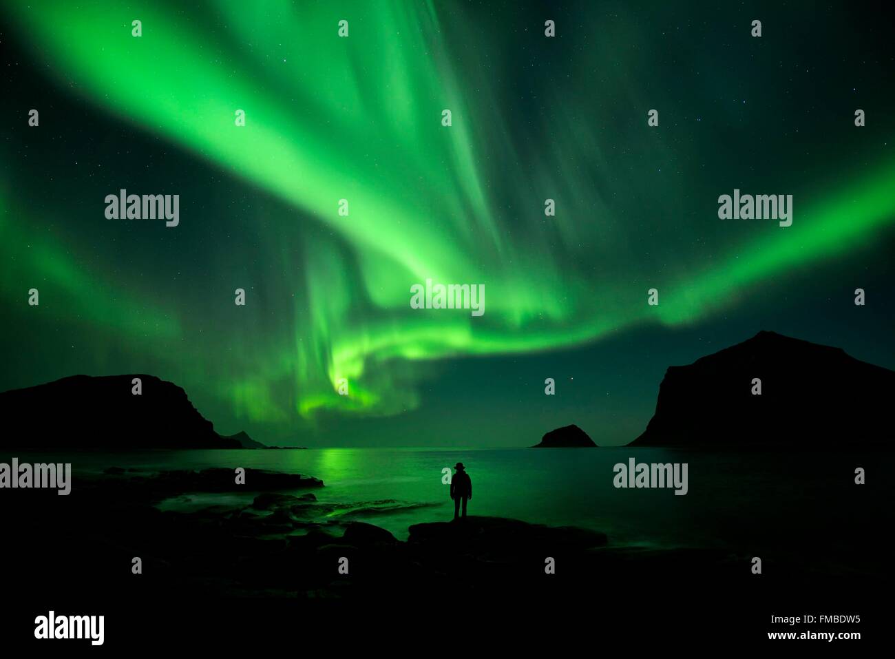 Norvegia, Nordland, isole Lofoten, isola Vestvagoy, Vik beach, silhouette di donna e di luci del nord (aurora boreale) Foto Stock