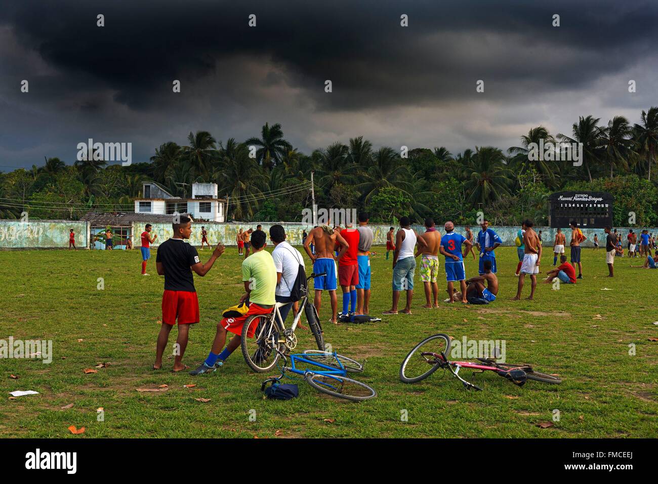 Cuba, Guantanamo Baracoa, football giocatori sul campo sotto cieli minacciosi Foto Stock