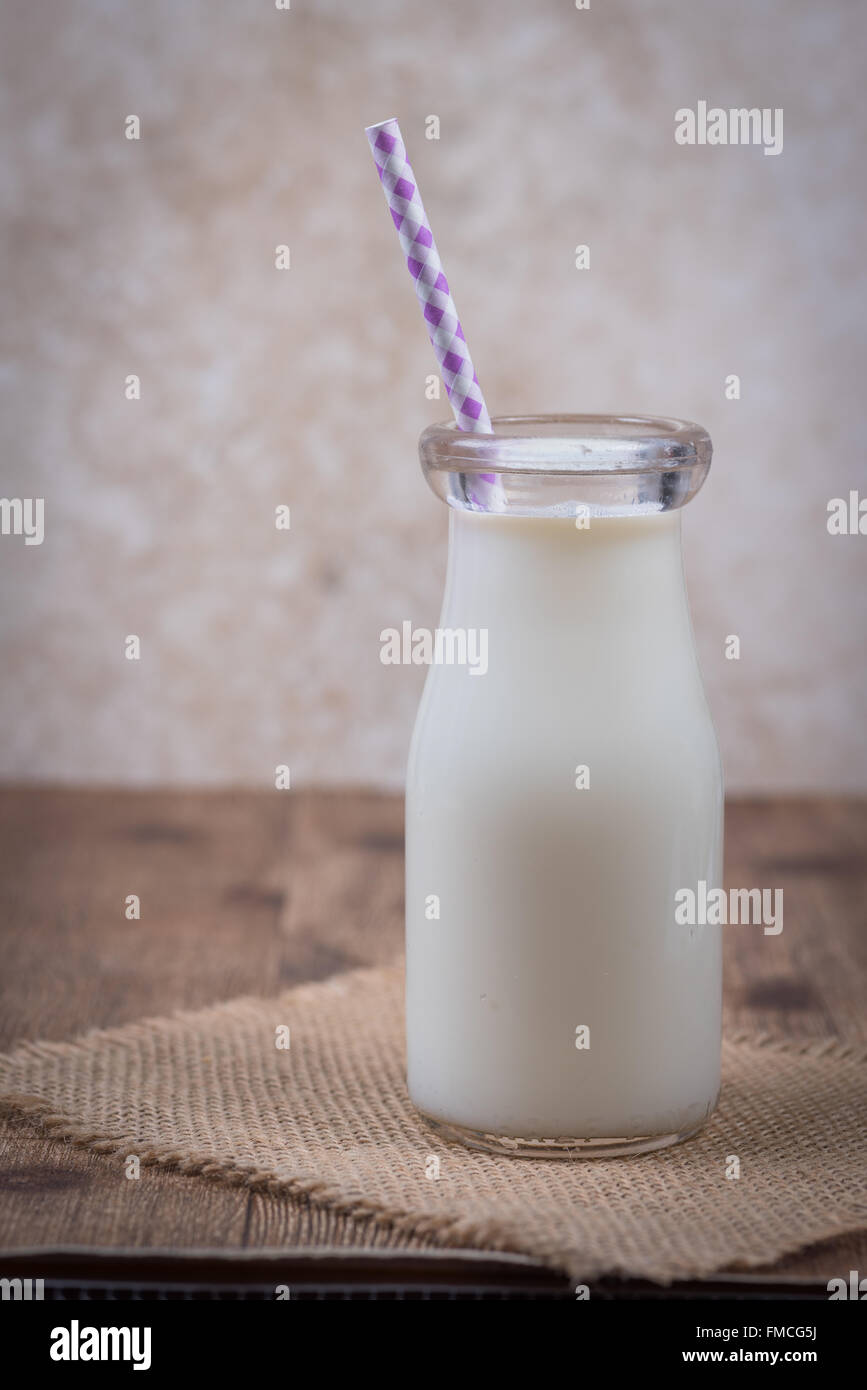 Bottiglia di latte con una verticale di paglia Foto Stock