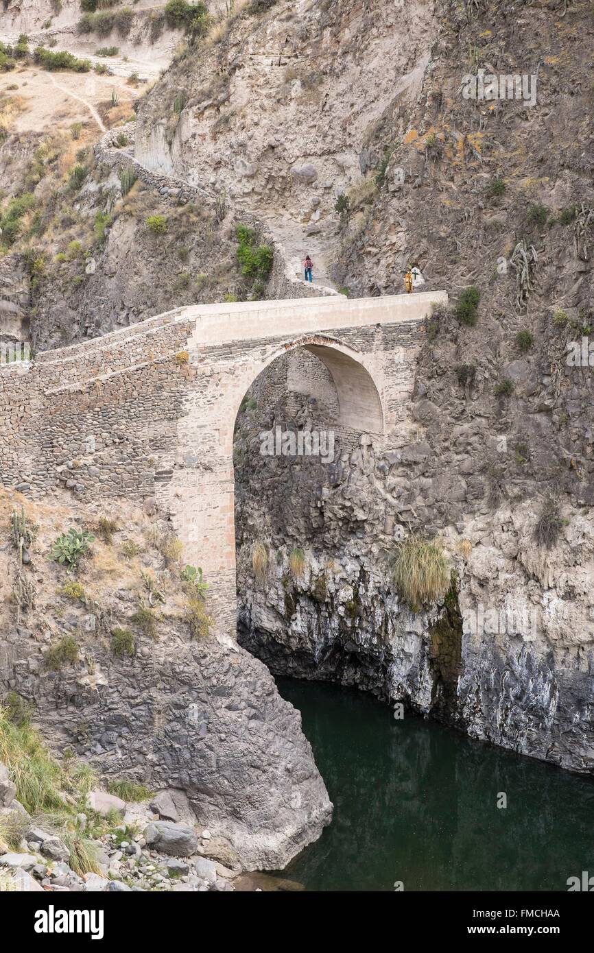 Il Perù, Provincia di Arequipa, il Canyon del Colca, Yanque village, ponte di pietra sul fiume Colca vicino al Chacapi hot springs Foto Stock