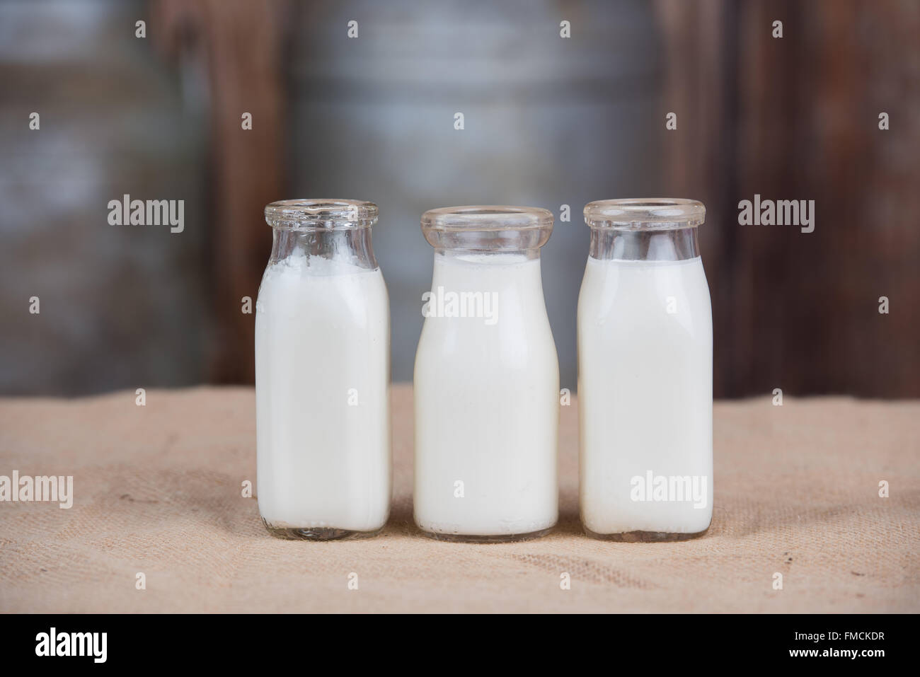 Vintage tre bottiglie di latte rivestito in una riga Foto Stock