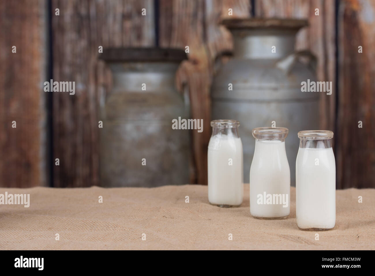 Tre vecchie bottiglie di latte schierate sul lato destro. Spazio vuoto sul lato sinistro Foto Stock