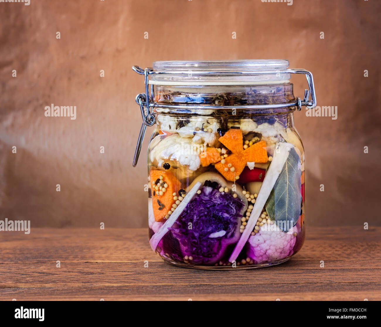 Jar assortiti di messi in salamoia lacto-fermentati sottaceti su un tavolo di legno. Foto Stock